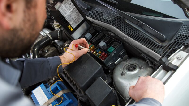 Tecnico al lavoro sull’impianto elettrico di un veicolo, immagine illustrativa